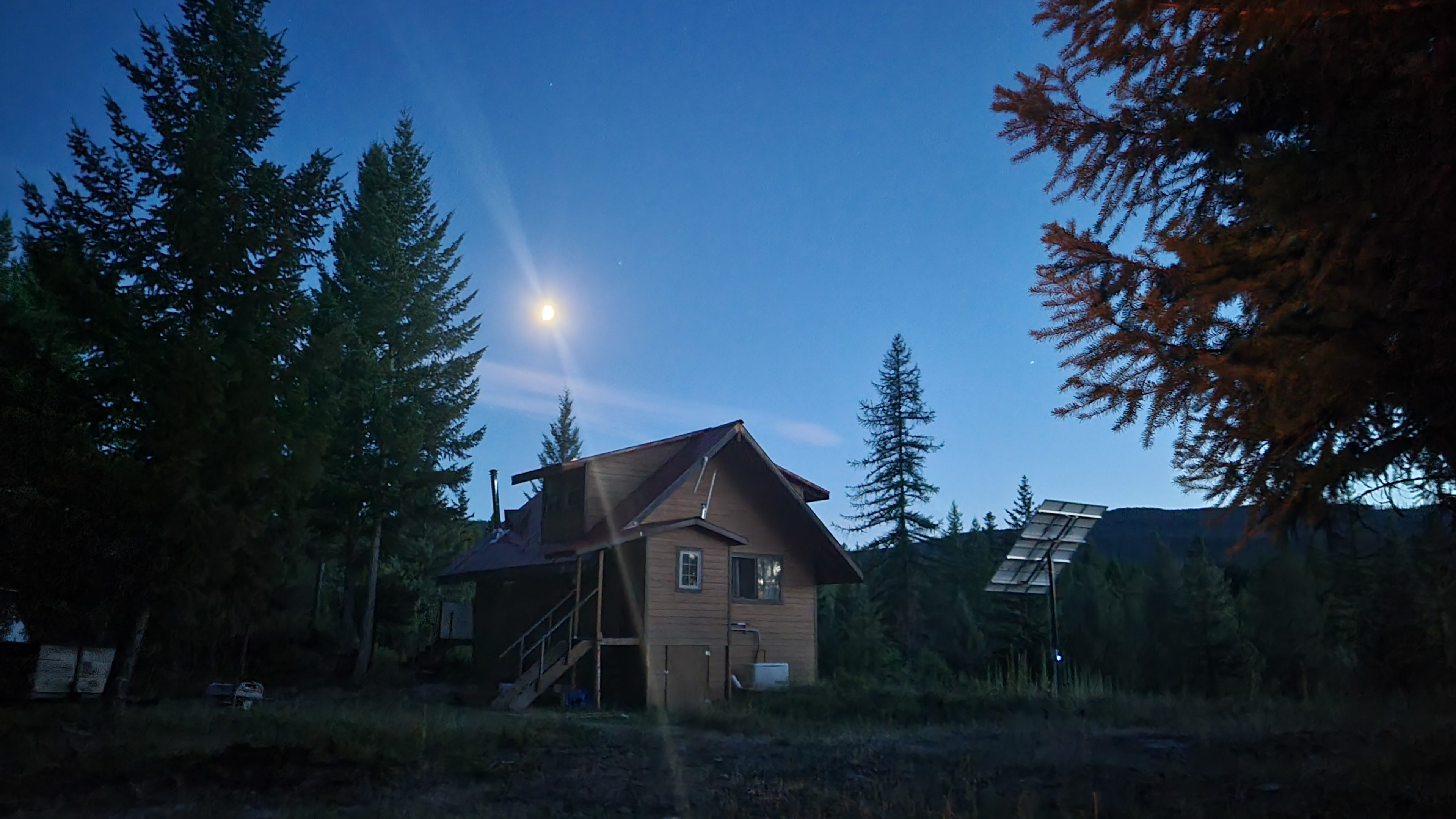 View of the back of the cabin in the evening from the fire pit.