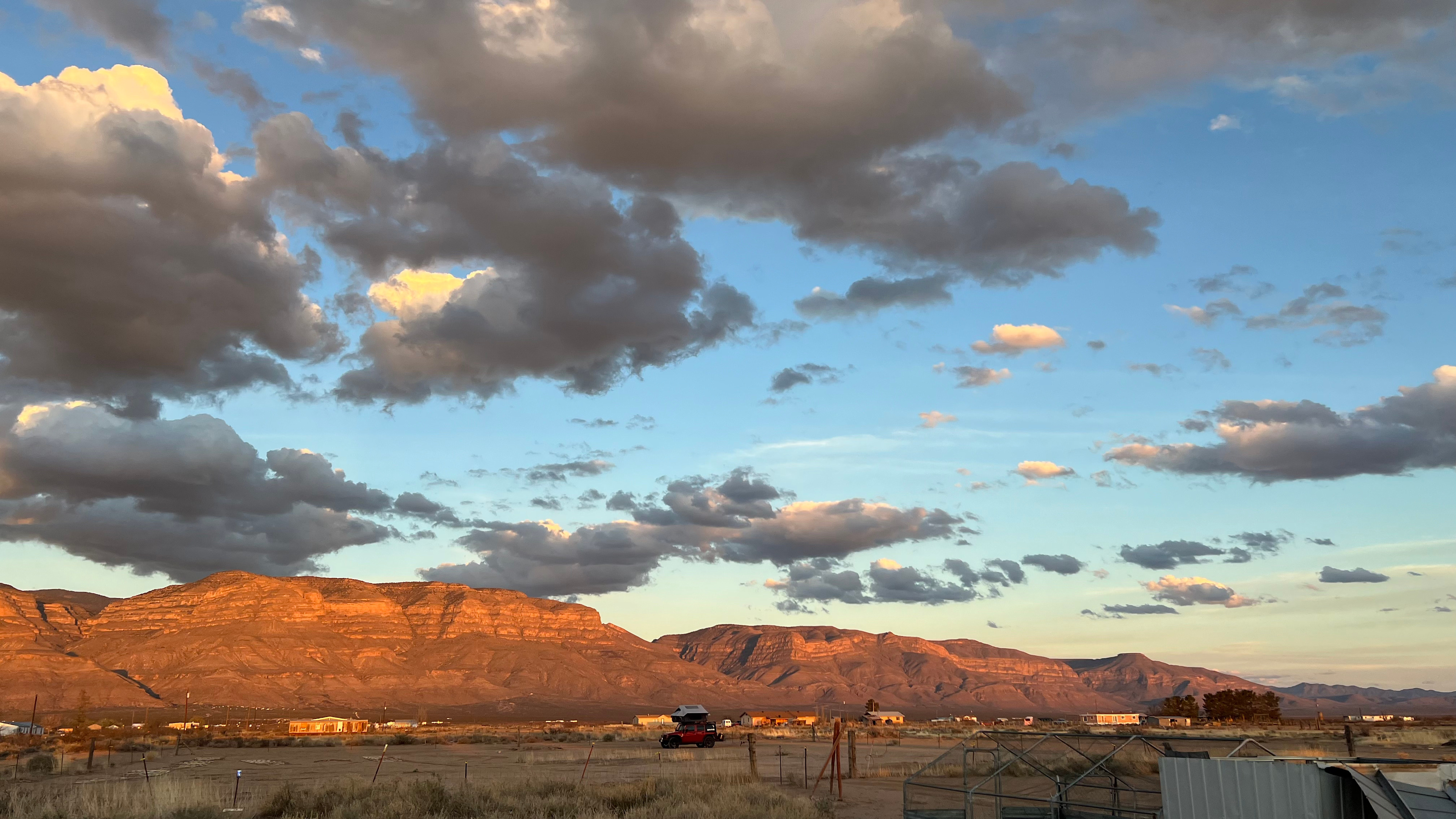 View facing east towards the mountains.  Setting sun’s orange light reflects off the mountains.  