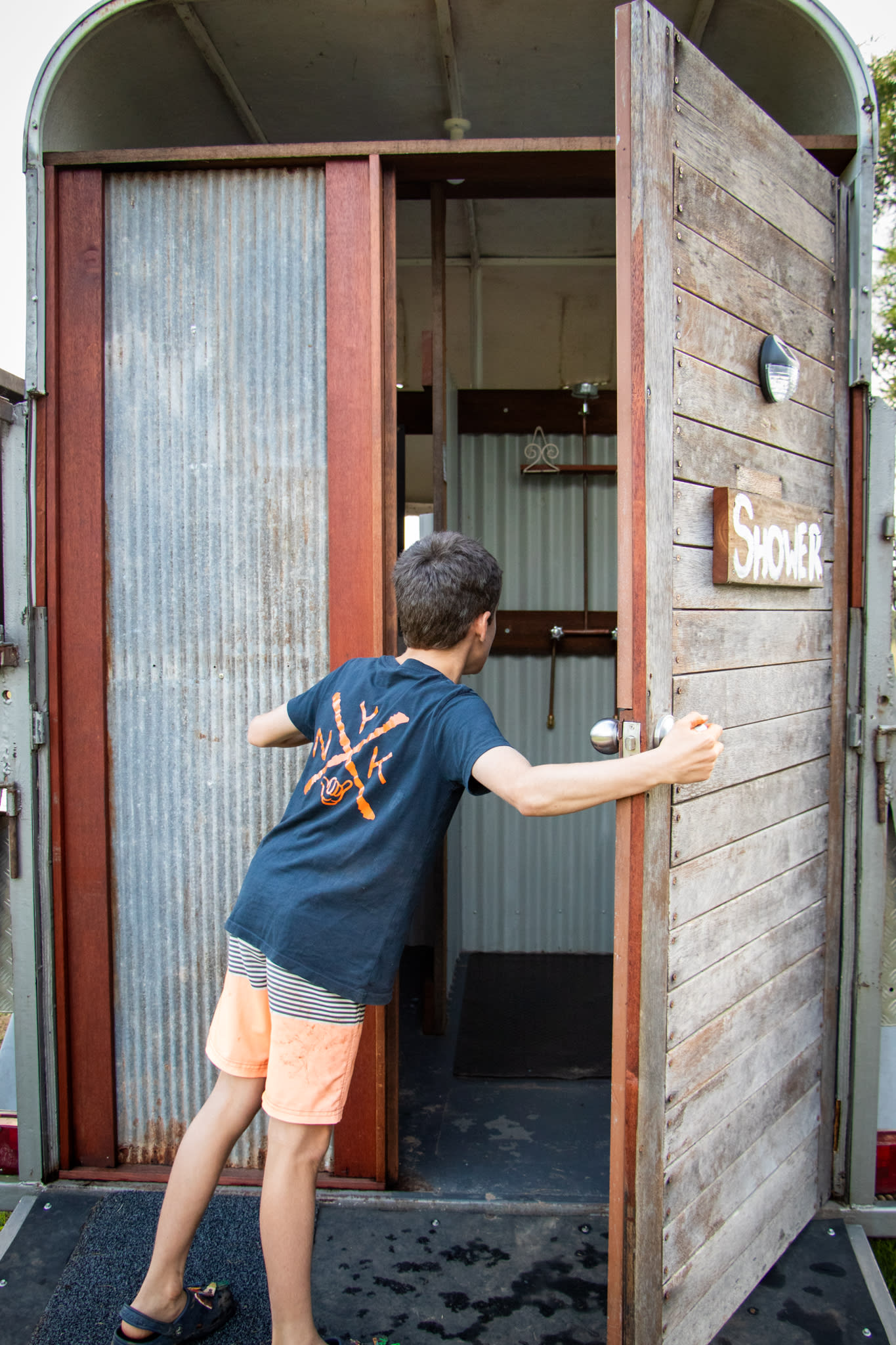 Quirky hot water shower in a converted horse float.