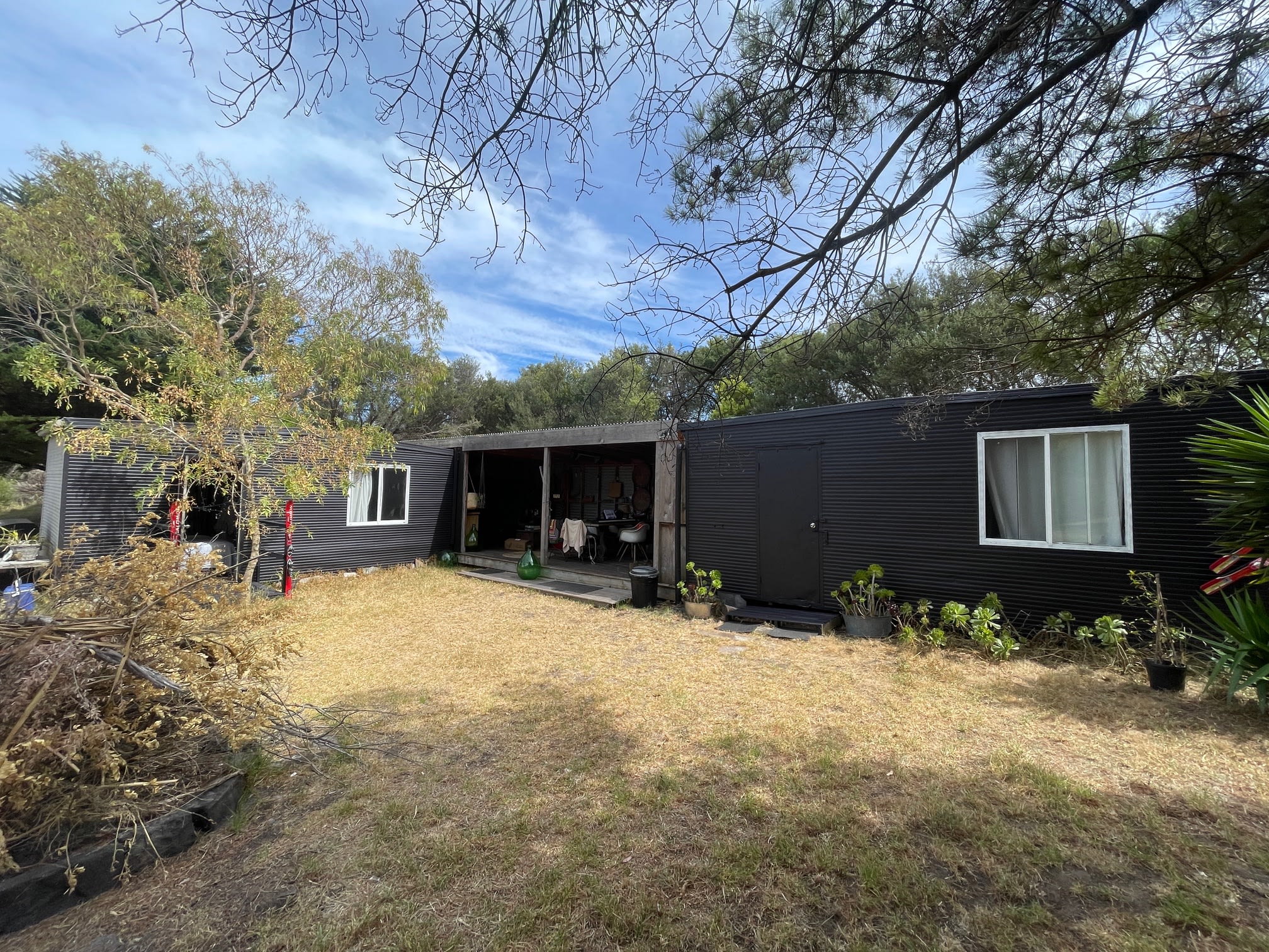 Cabin 1 (suits a single or a couple on a super comfortable king bed) is on the left and 

Cabin 2 (can sleep 1-4 people) entrance is on the right. If booked separately or the property on a different listing. It has 2 double beds - great for families or a couple of friends. 

These are a little like converted shipping containers but have everything you need in them for a great nights sleep. 

The middle section is where the kitchen, lounge, fridge, frezer etc is.

The fire pit on is in a perfect spot for gatherings not too far from the kitchen and bbq area. Fire Restrictions apply. 

Pull up a camp chair and chill out to a few tunes. Happy Days!