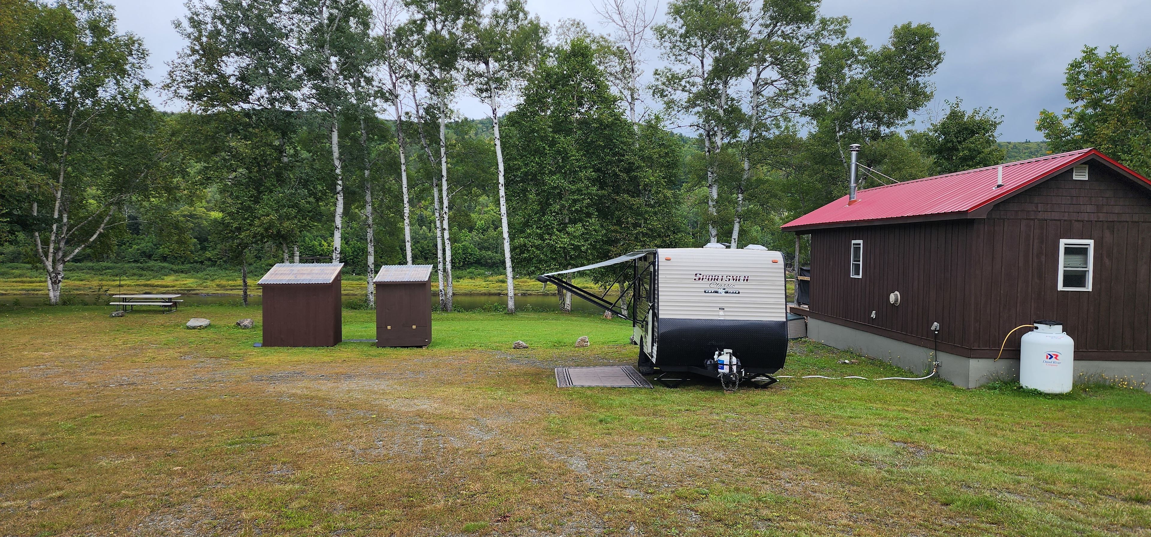 Site 5 has sewer hookup next to the cabin.  The electrical connection is on the side of the cabin.  Your RV can be parked parallel to the cabin (as depicted in the photo) or backed in perpendicular to the cabin.  