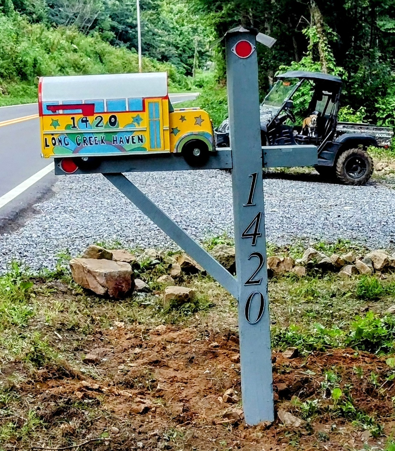 Colorful skoolie mailbox located at the entrance to Long Creek Haven
