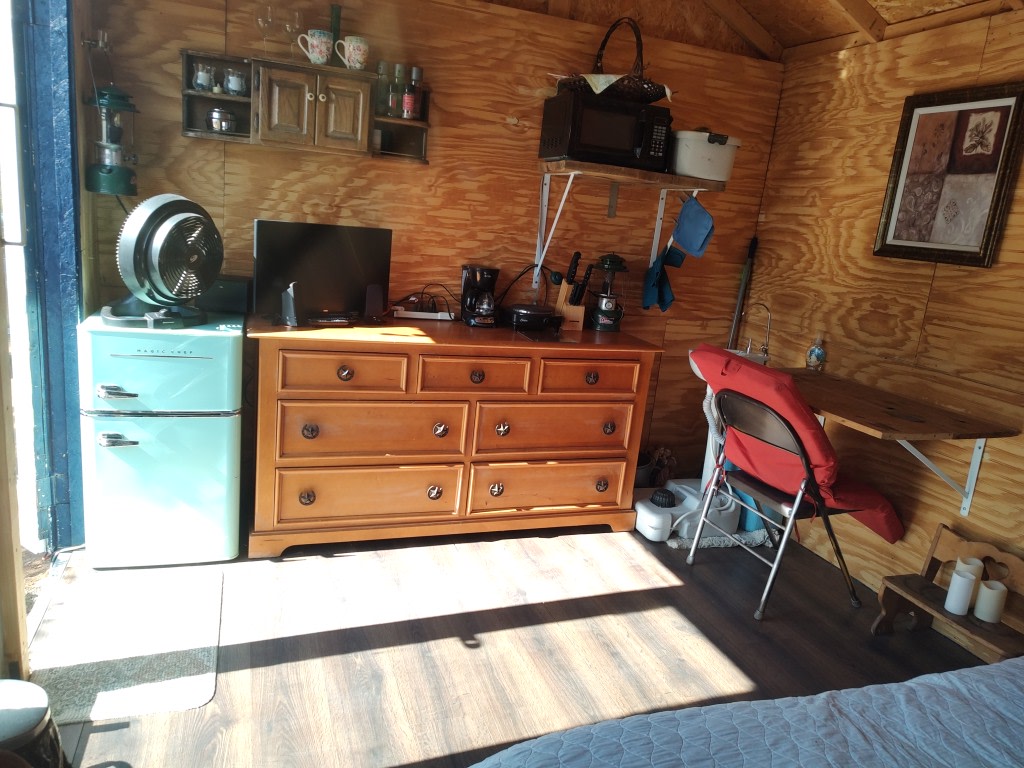 This little kitchette has everything you need for your weekend getaway.  A cold refrig/freezer, coffee maker, coffee, tea and mugs.  Microwave, heat plate, silverware, plates, cups, pots and pans inside the cabinet.  Sink to the right and a desk.