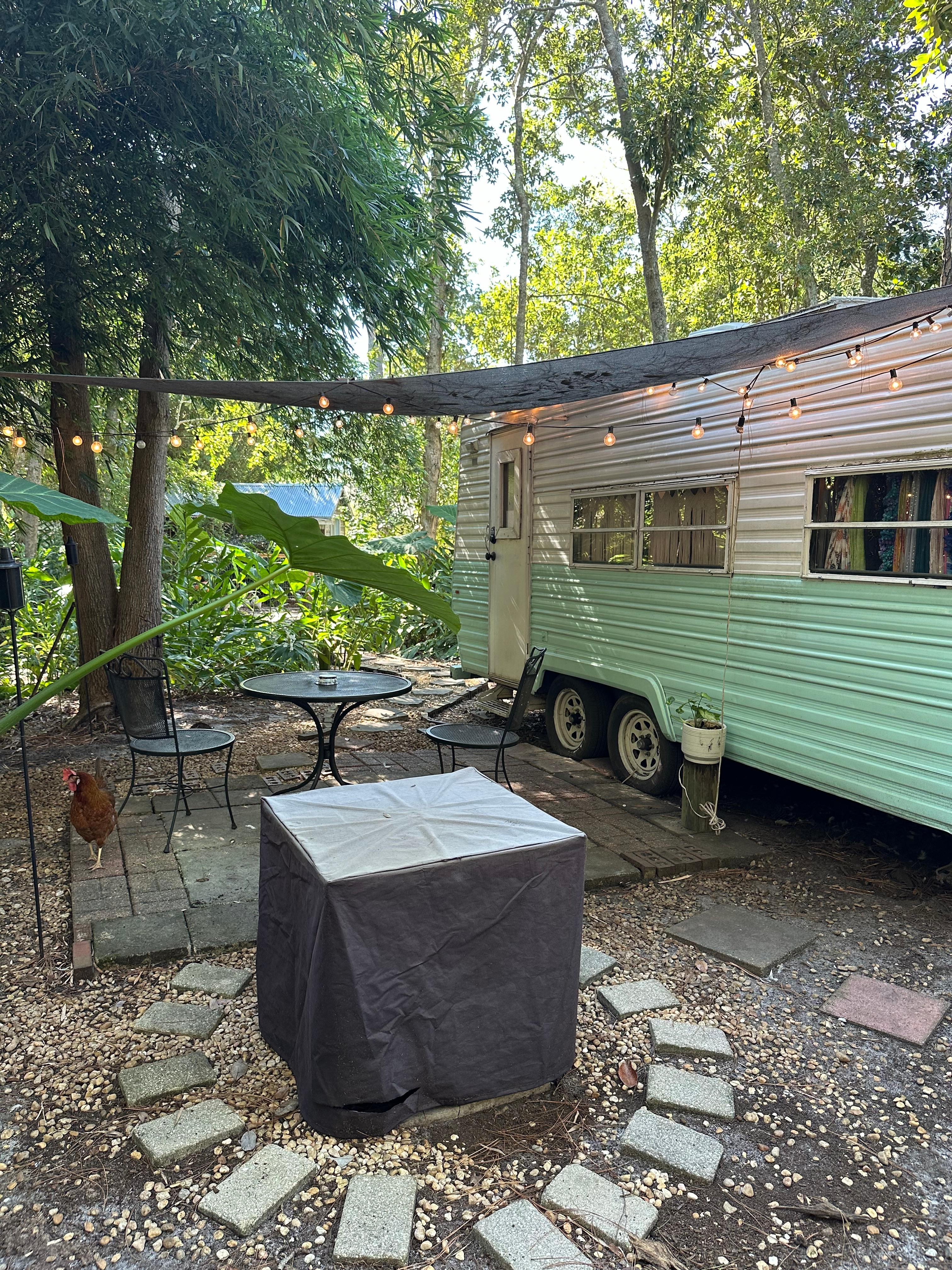 Vintage camper with full hookups and a propane fire pit. 
