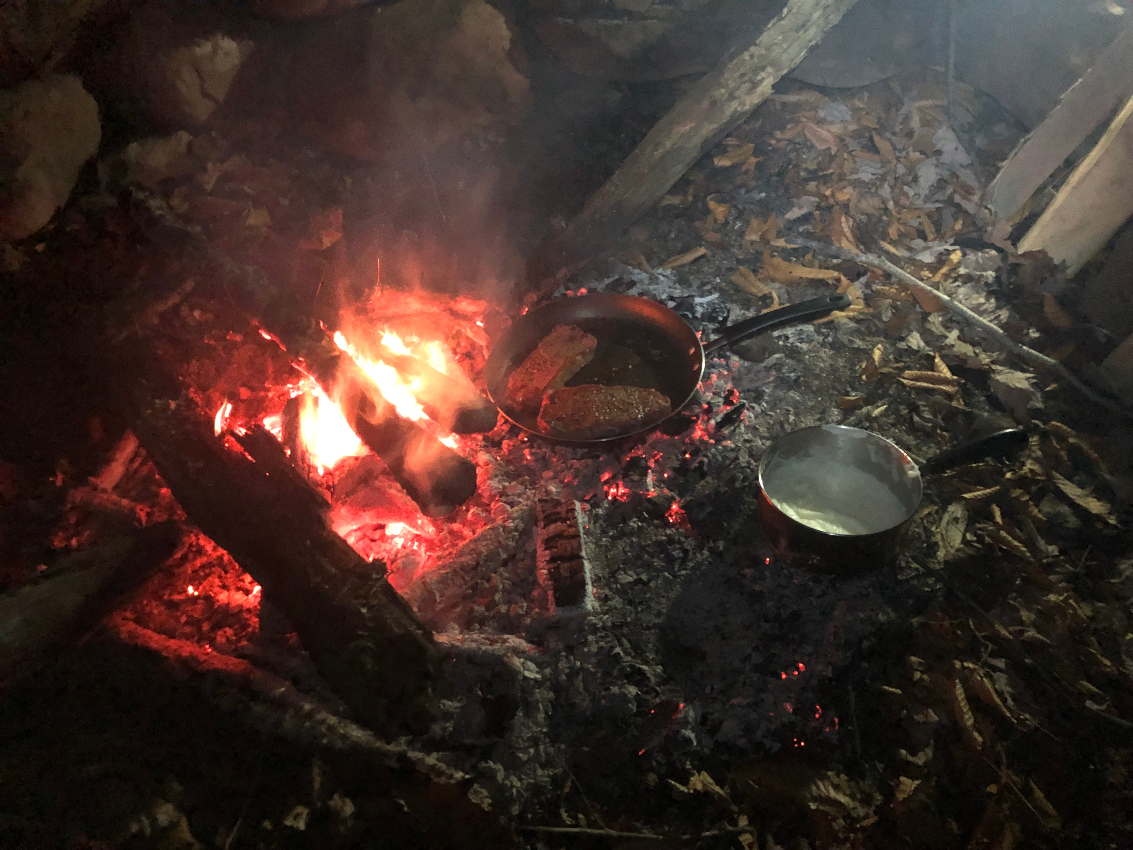 Frying up steak and potatoes in the fire pit