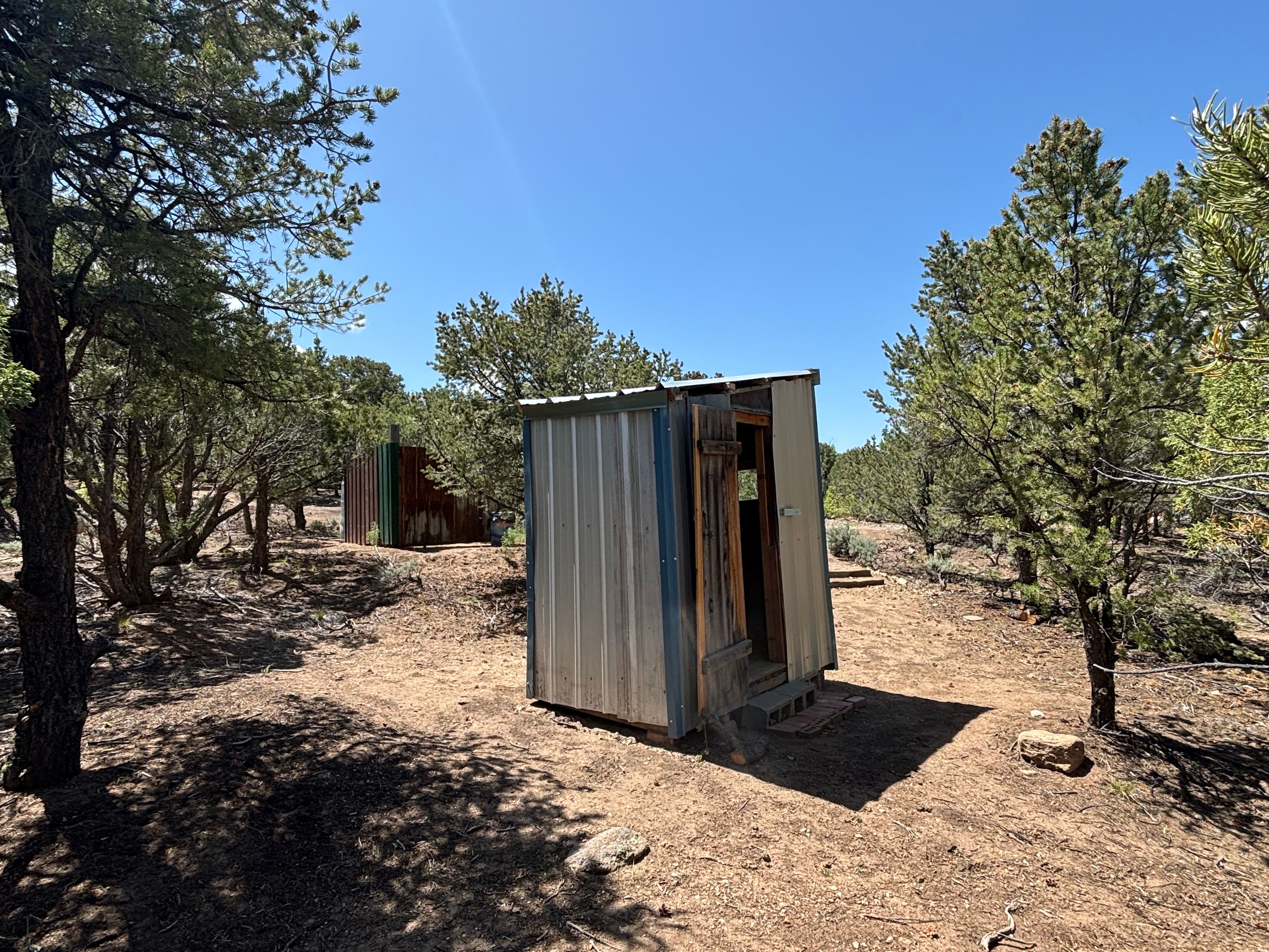 Outhouse, with solar shower enclosure in background.