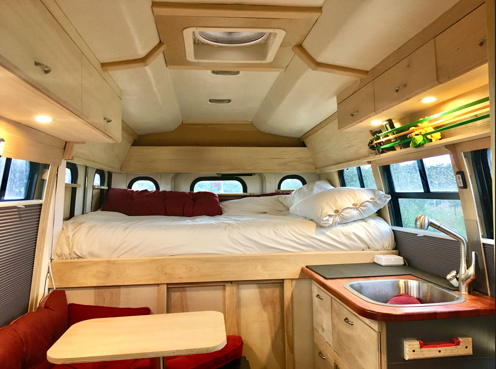 Our cozy Bus Tiny Cabin.  Running water, full sized bed. microwave, ceiling fan, solar power, WifI, wood burning stove, fridge and great big Shuttle bus windows facing the mountains.