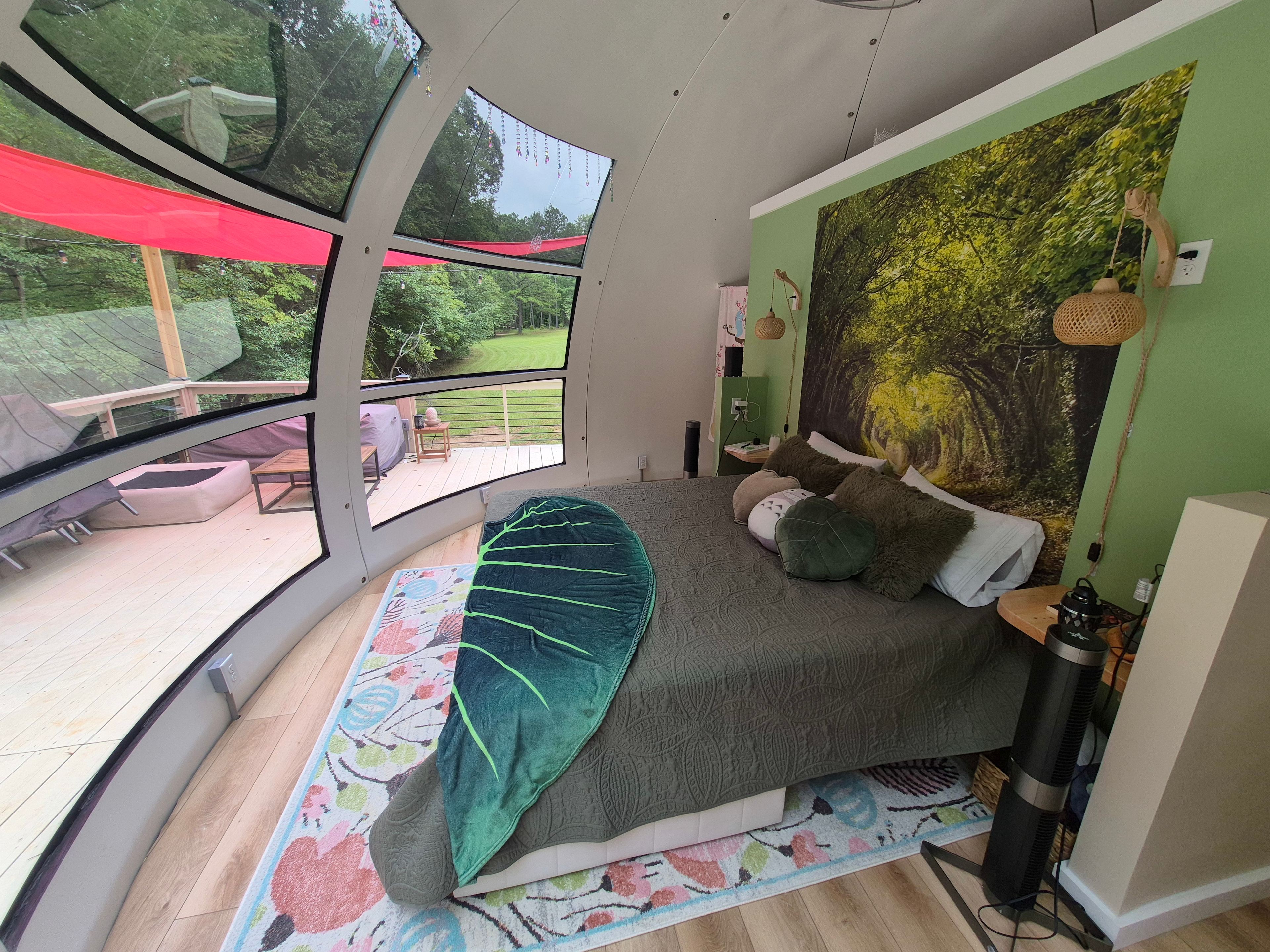 Sleeping with King bed and view to the woods through the floor to ceiling windows