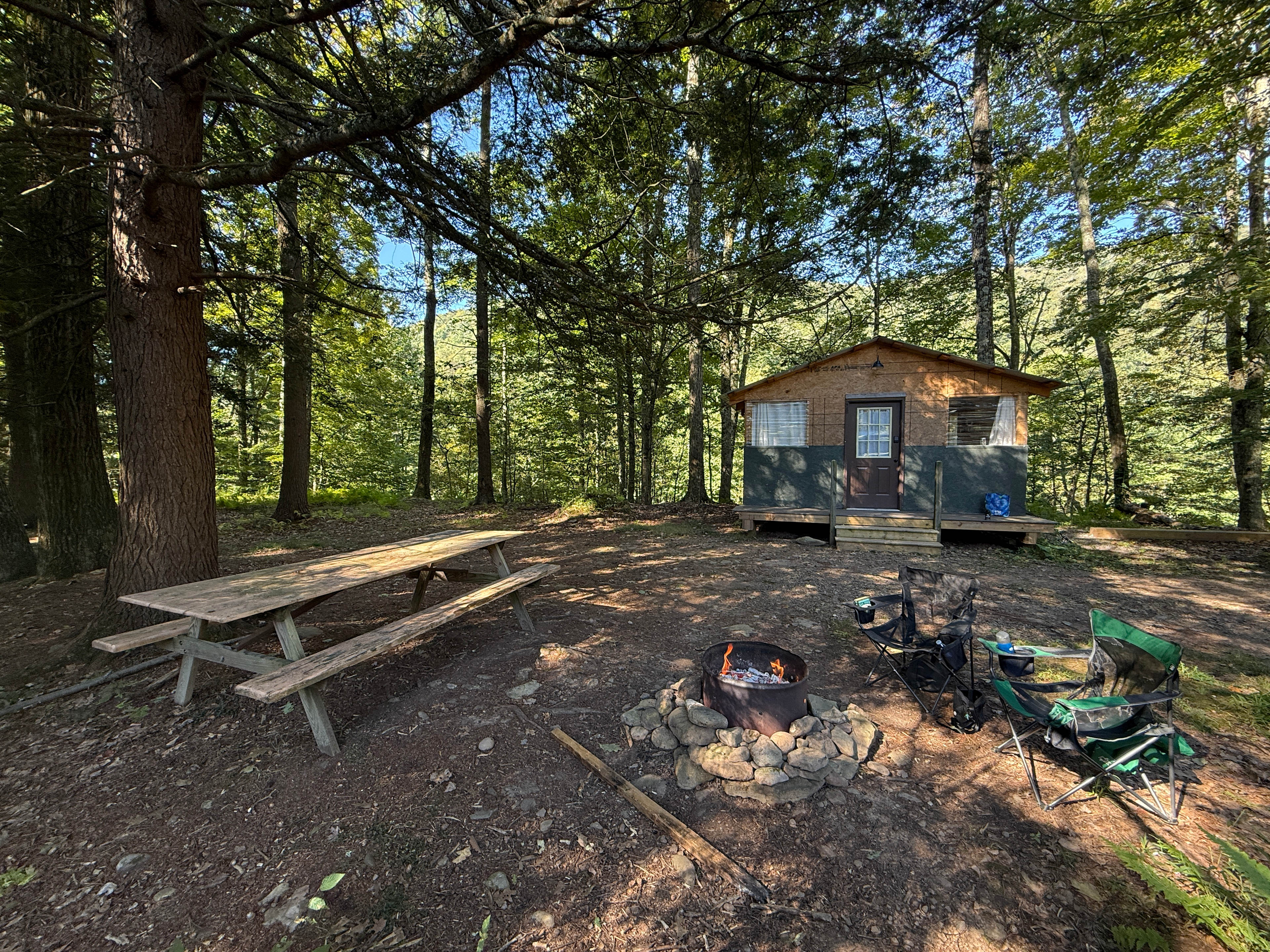 View of the front of the cabin and fire pit area