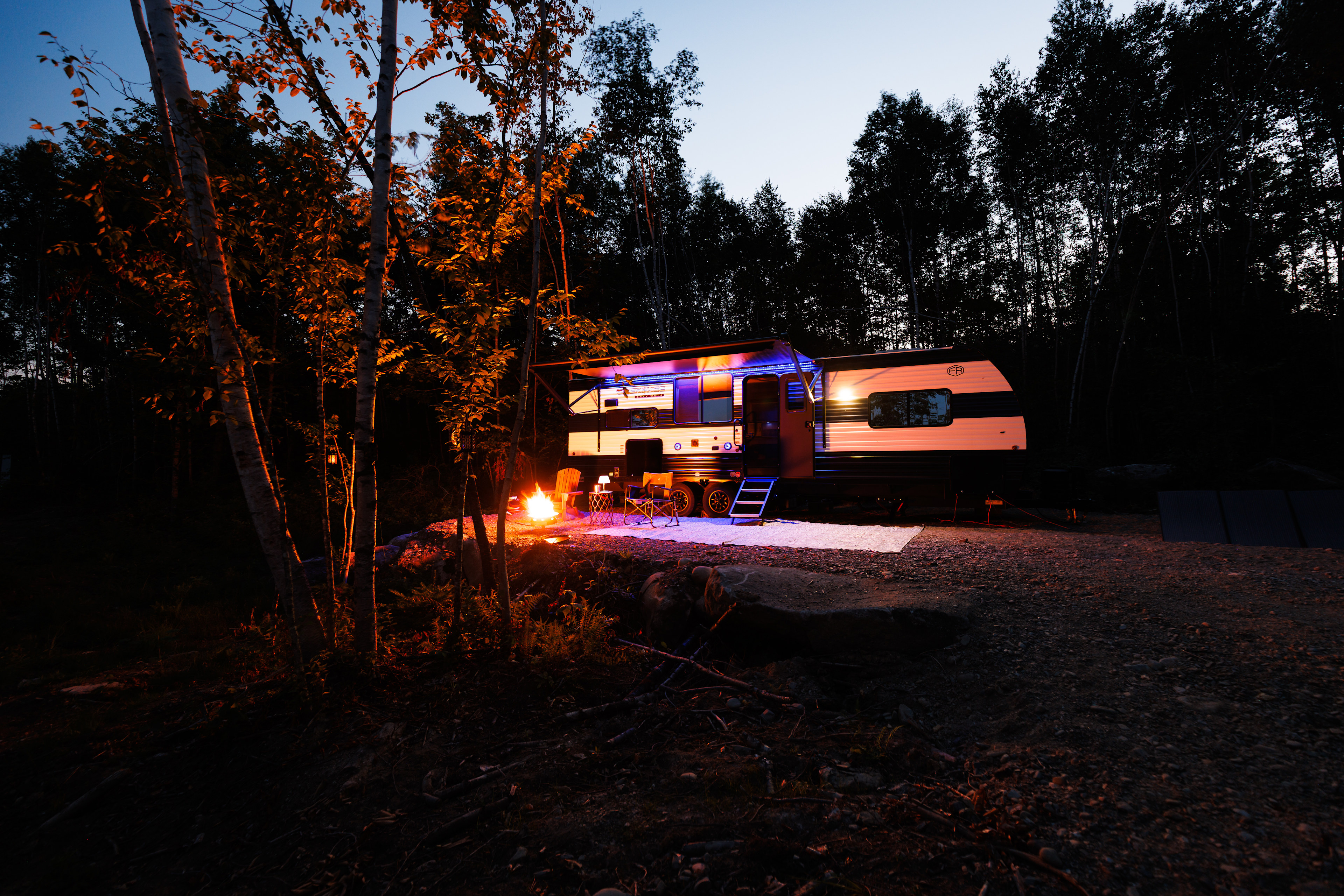 Front view of the RV at night with the gas fire pit on.