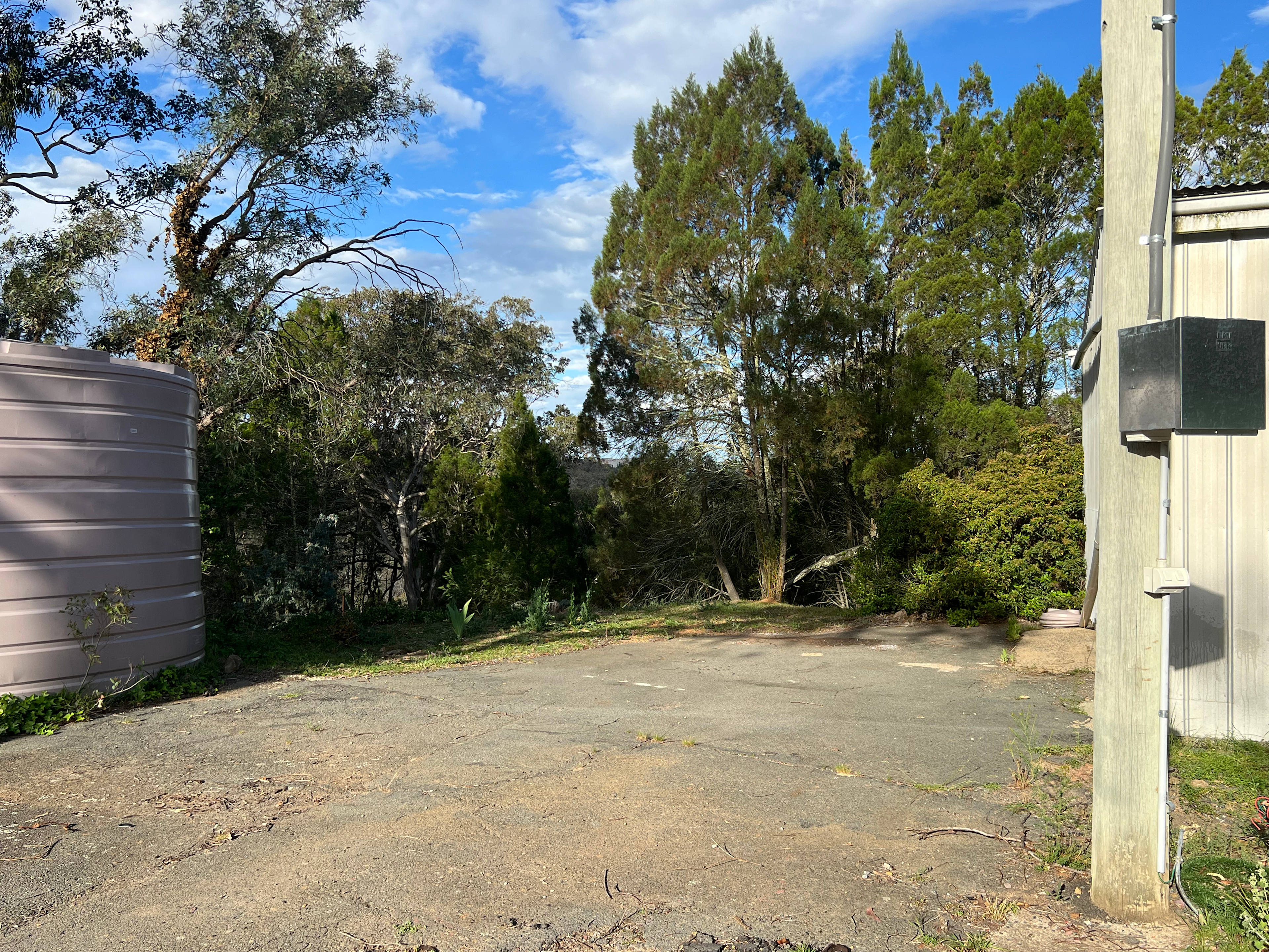 This is the site, large asphelt area, near power supply, grass/dirt area of several metres at back of site. Large turning space in front of site. Back of site has view down into bush and over to the Molonglo Nature Reserve.