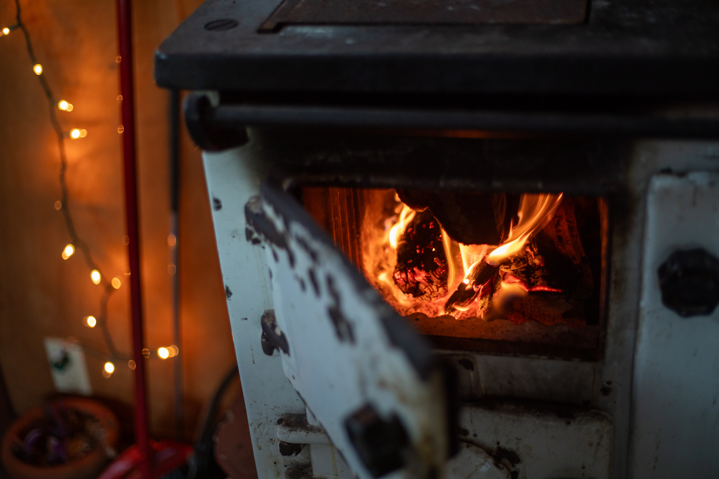 Adding more logs to the wood stove