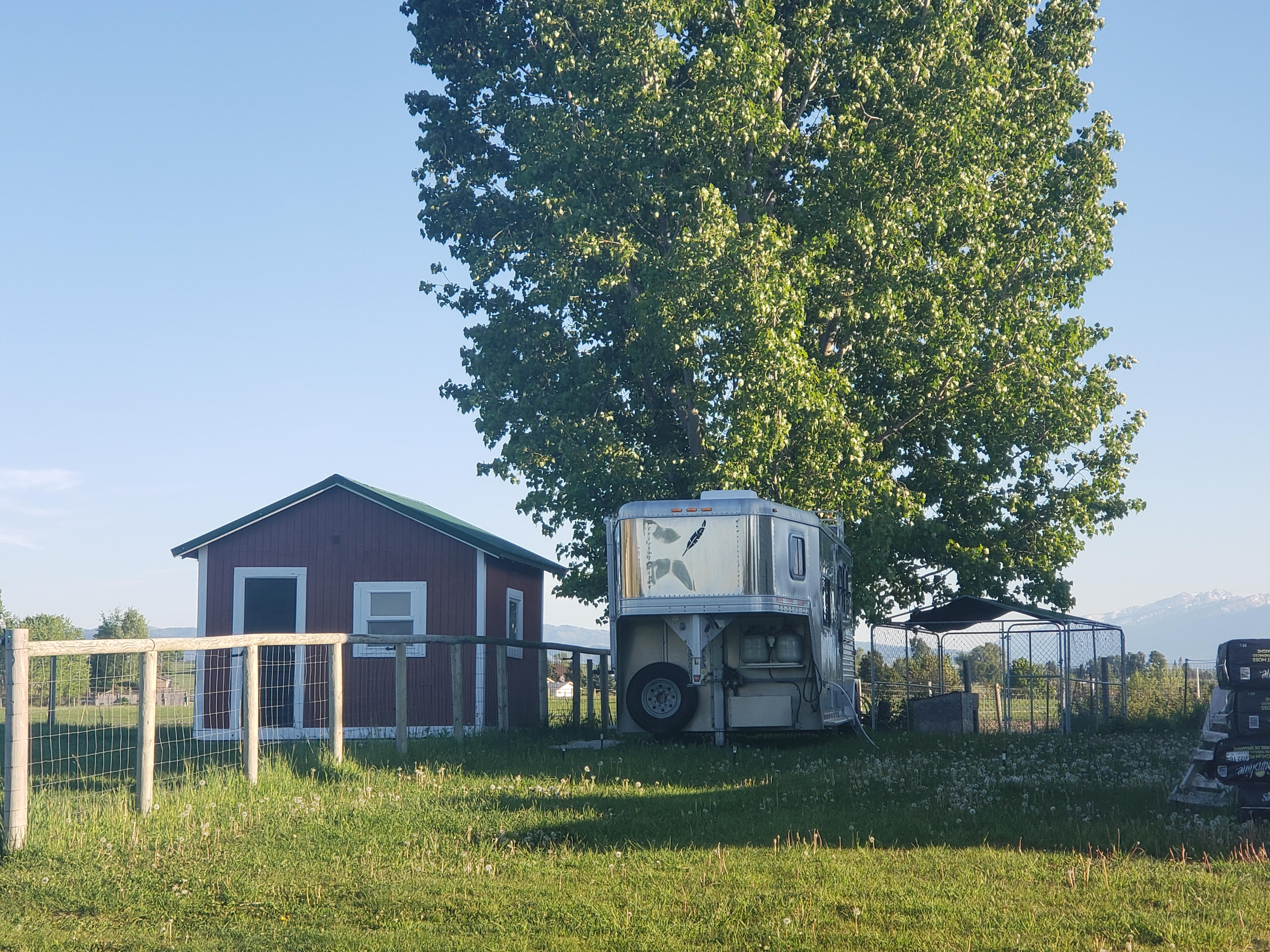 Trailer during summer parked next to the house.