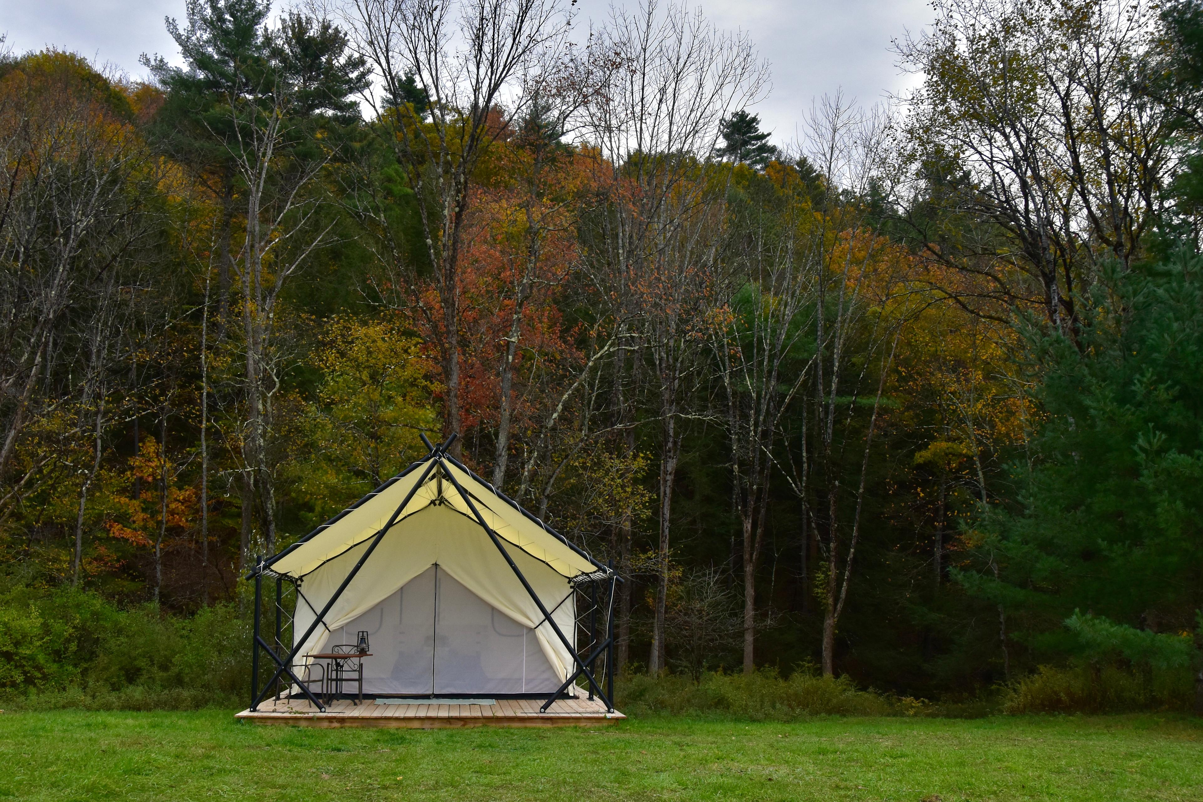Fully furnished crest tent with queen size bed, night stands with rechargeable lamps, indoor table and storage. 
