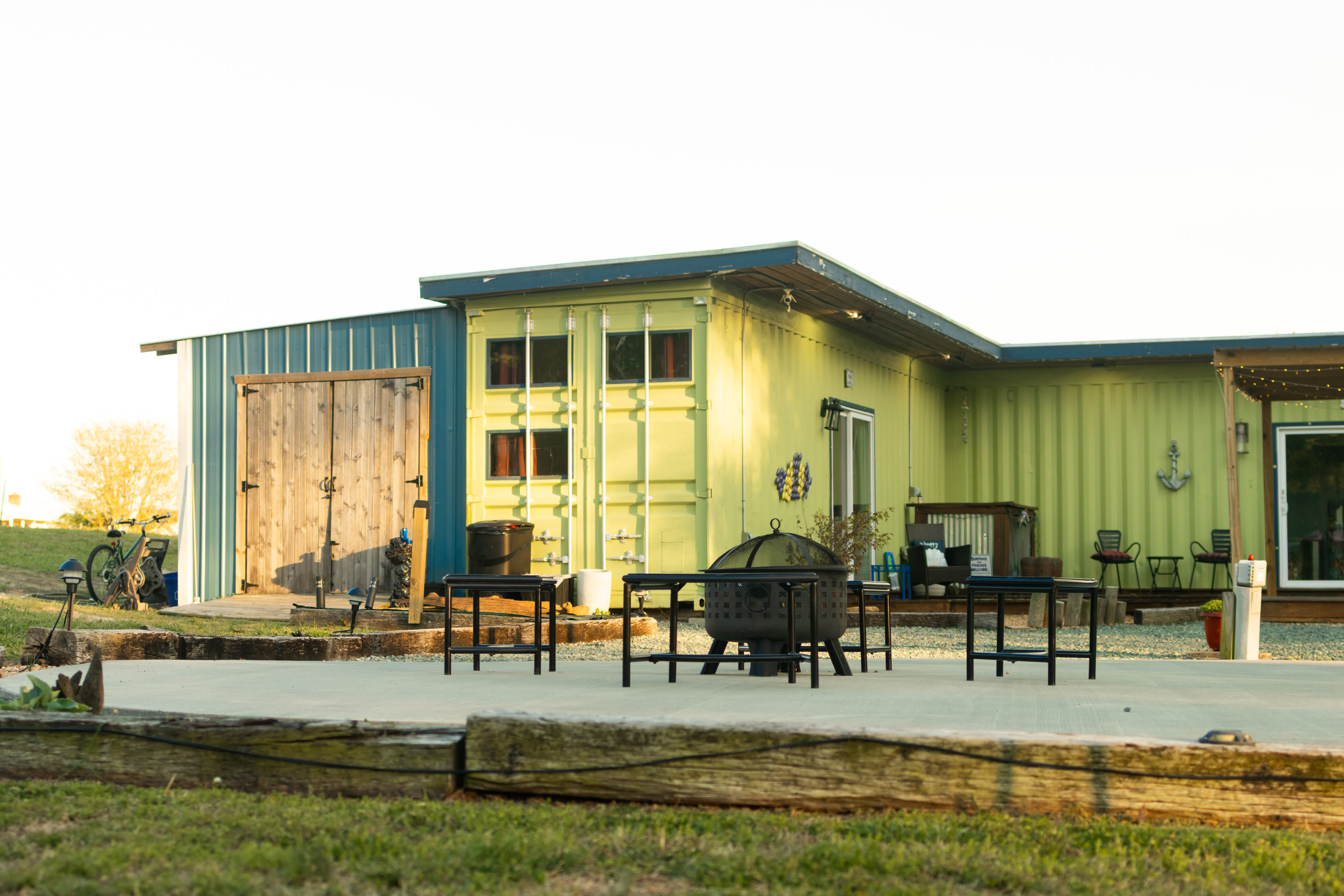 The shipping container common area has a firepit for all of your camping needs!
