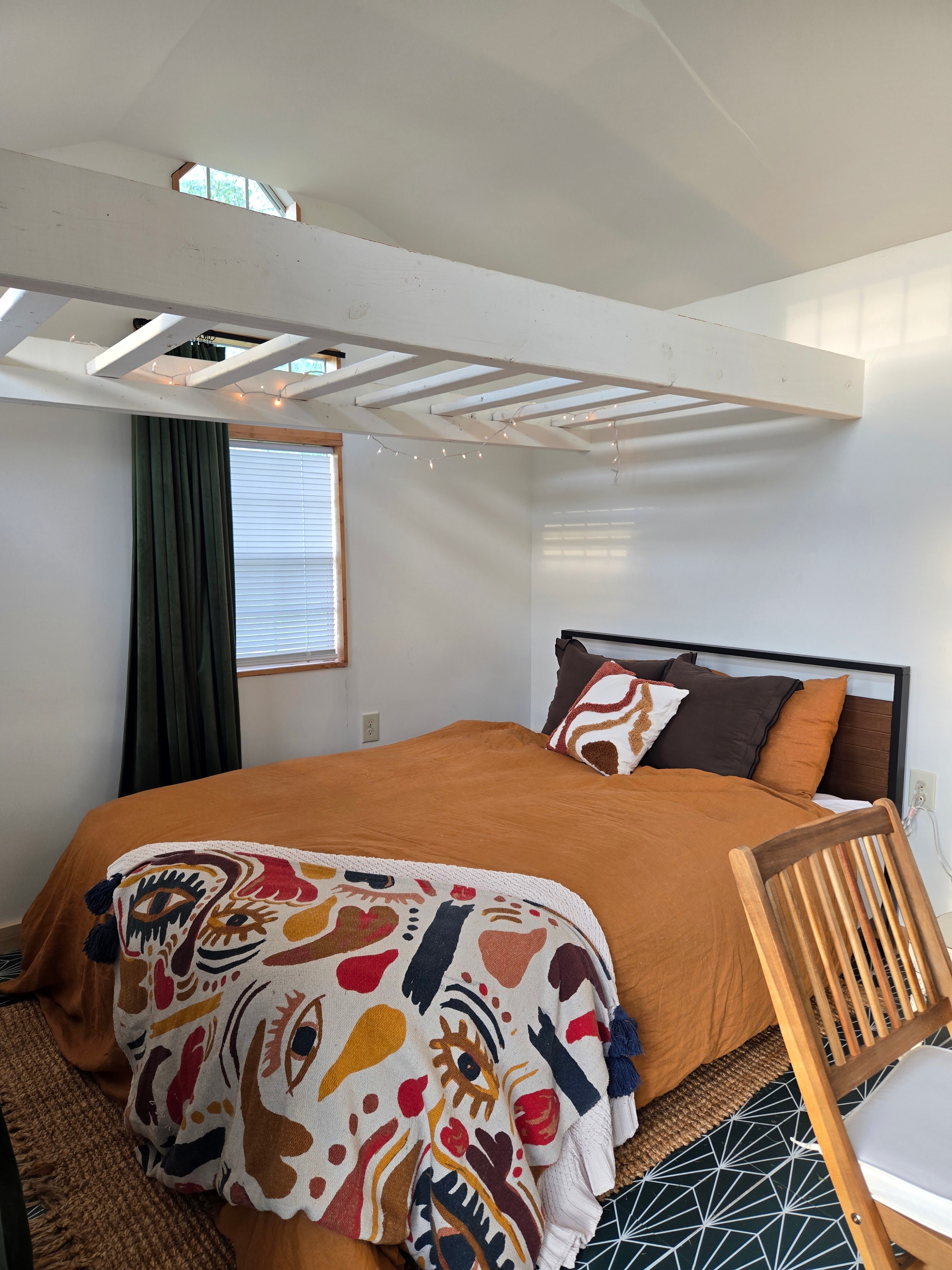 Comfy queen bed with organic cotton sheets, organic French linen duvet cover, fluffy goosefeather duvet, and hotel pillows.