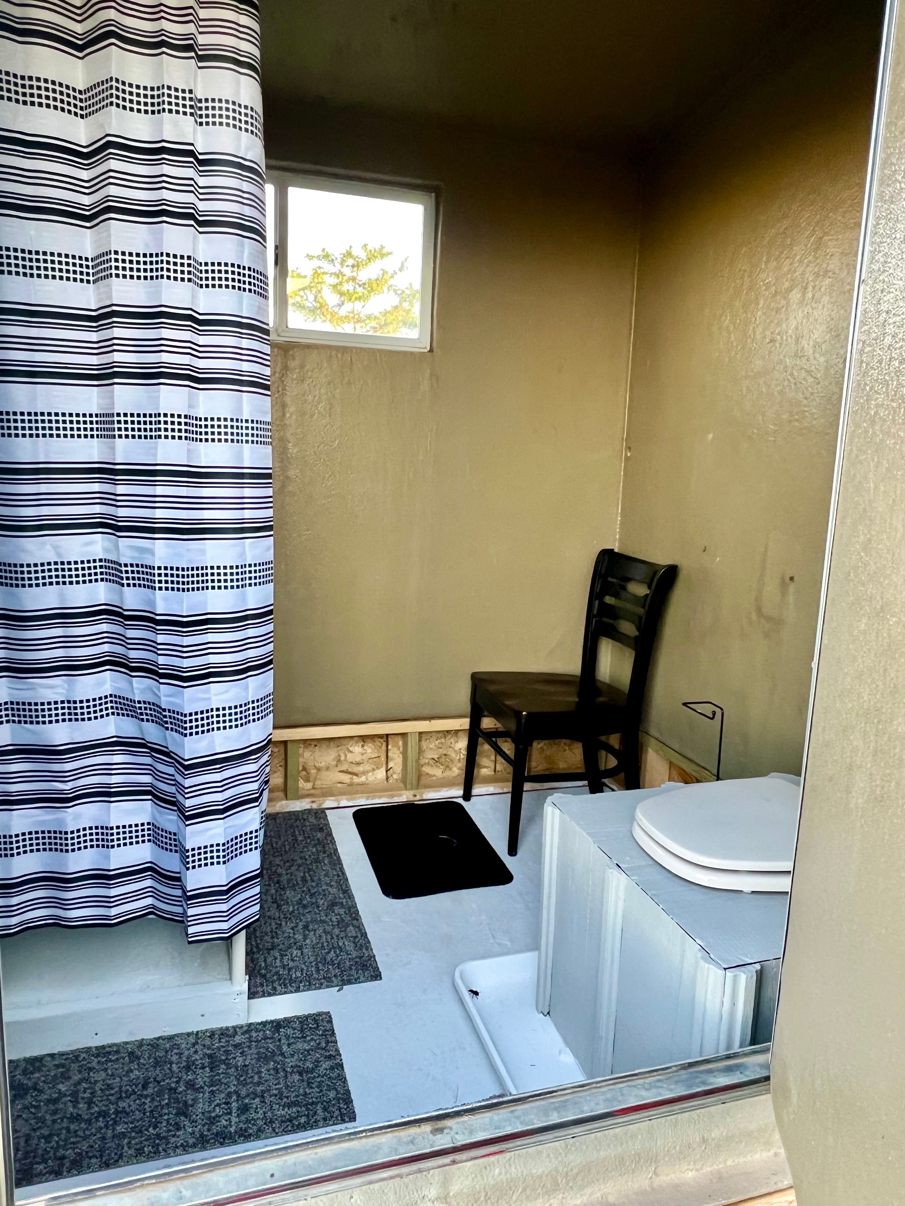 Interior, private BADLANDS BATHHOUSE (work in progress), steps from the BADLANDS BUNKHOUSE Prairie Retreat cabin. Hot/cold shower and compost toilet. Please use only the Dr. Bronner liquid soap, provided! The gray water drains directly to our honey locust patch.