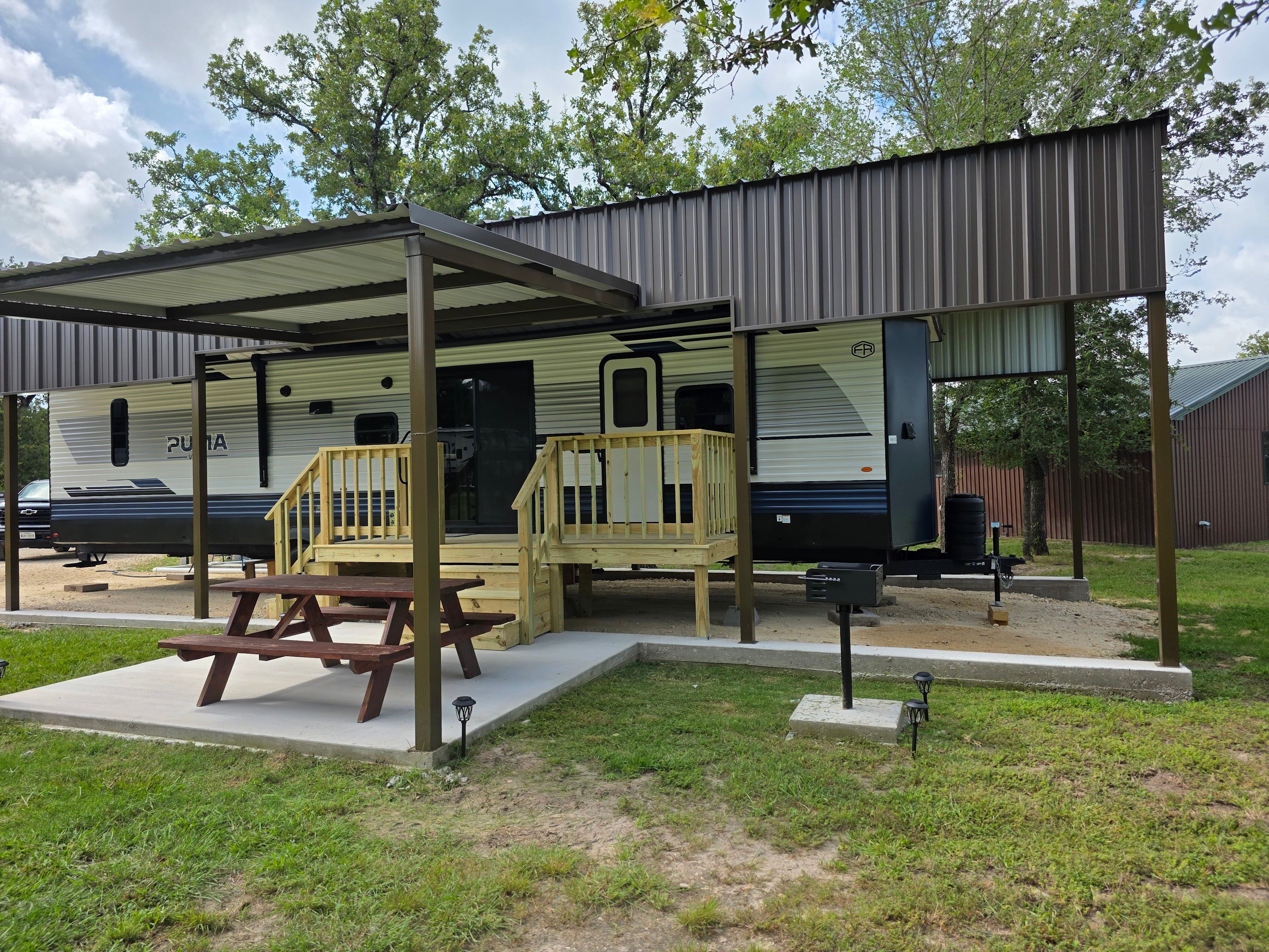 Front view of RV with Porch, grill, deck. 
