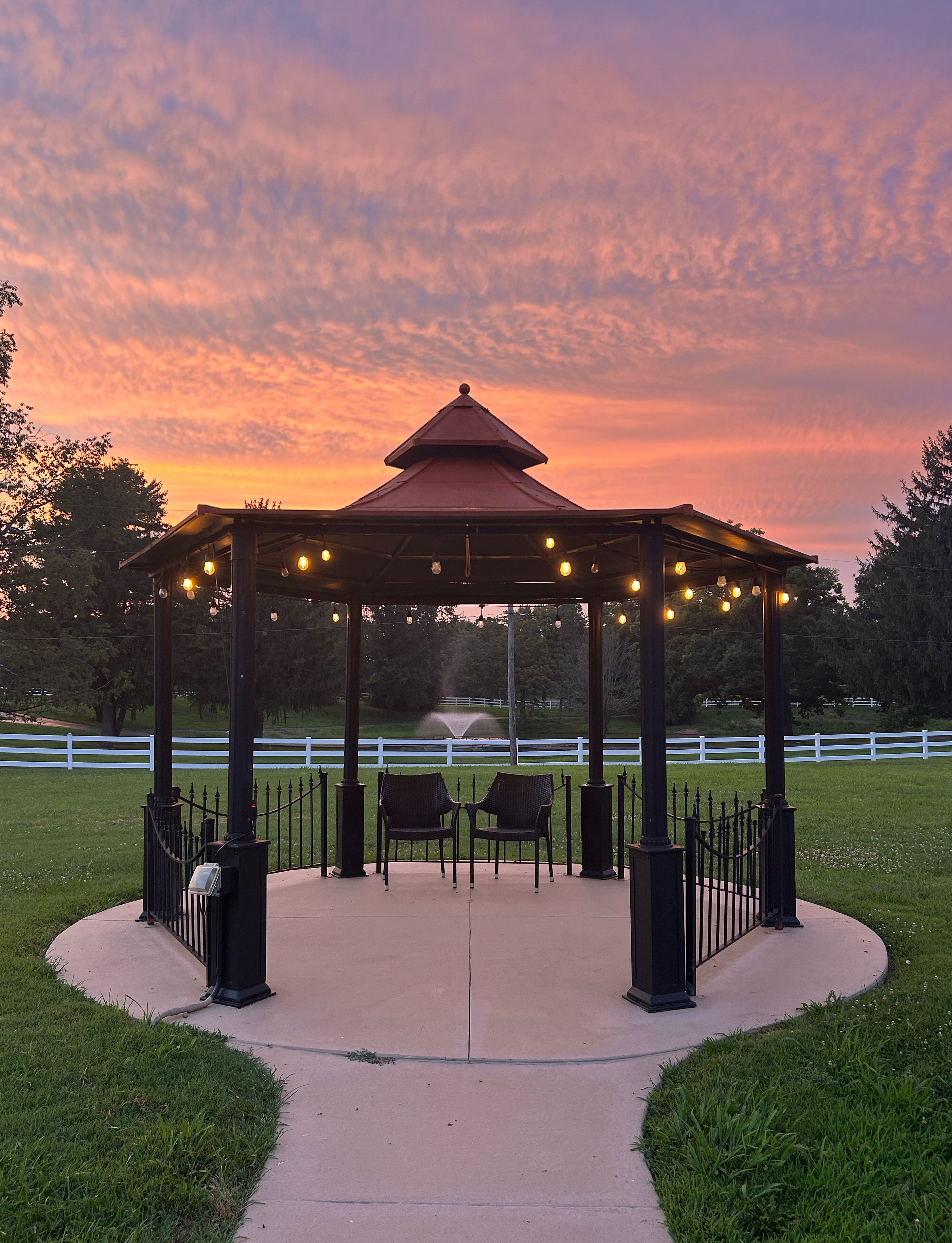 Covered pavilion at sunset with pond view in background