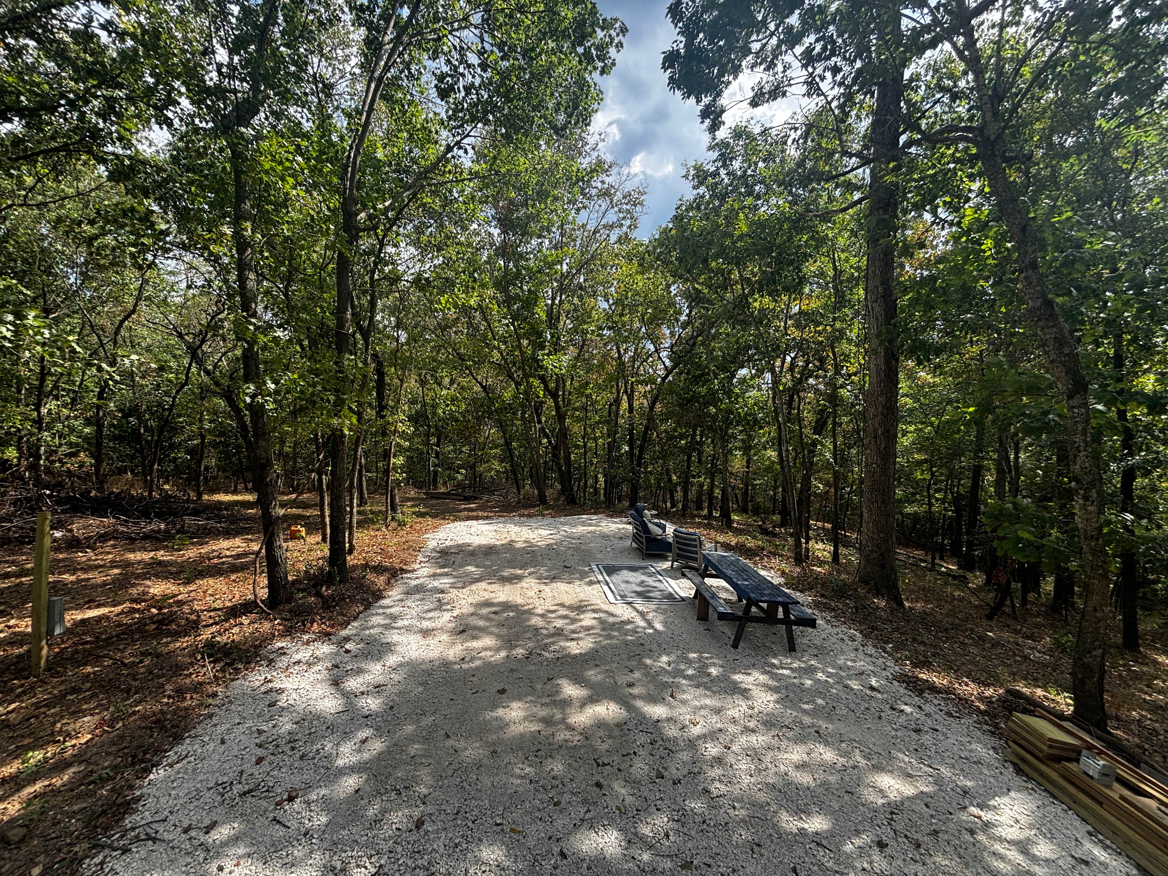 90% shaded! Large gravel pad with picnic table, conversation set, and cowboy fire pit. 