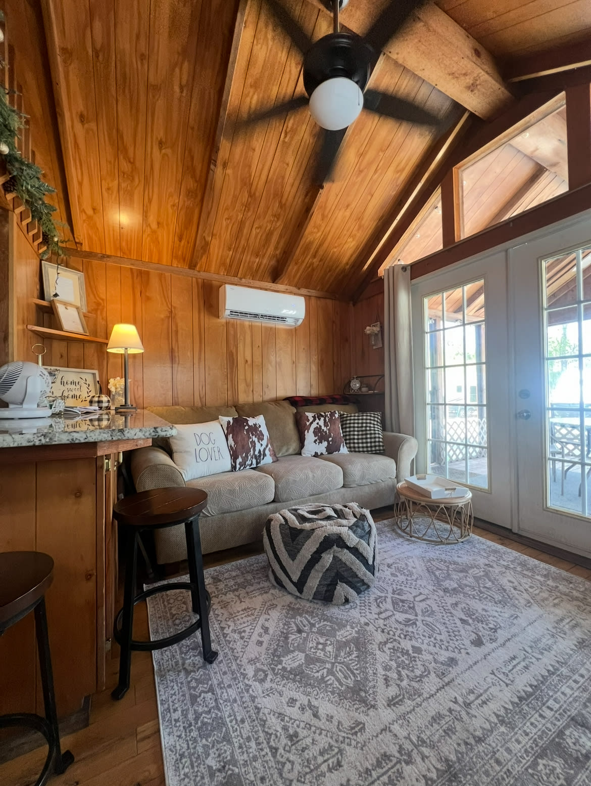 Comfy couch with large TV and electric fireplace, large granite island and there’s another single upholstered chair not shown and each bedroom has a TV