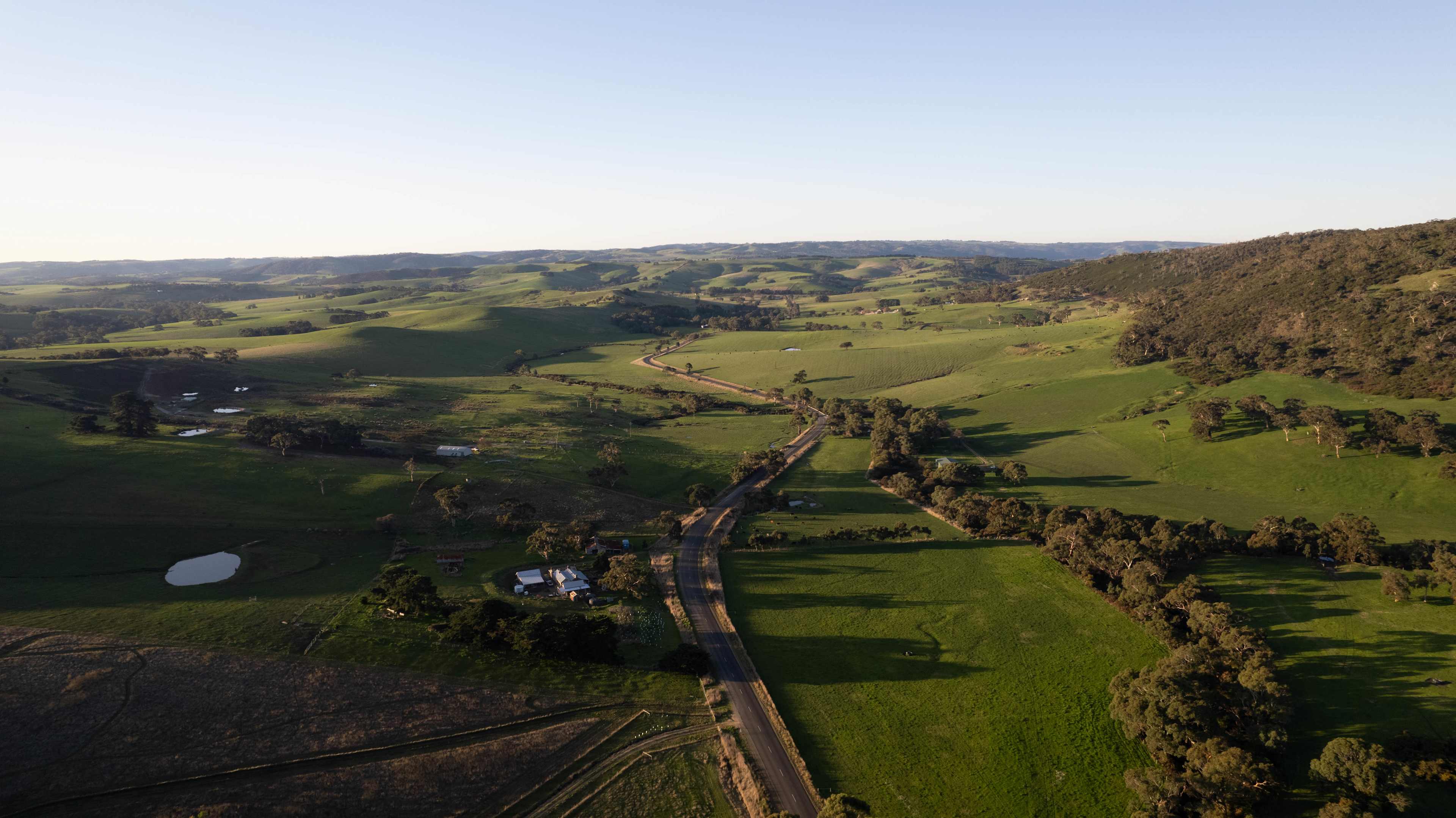 Aerial view of road towards campsite. Surrounded by beautiful hills.