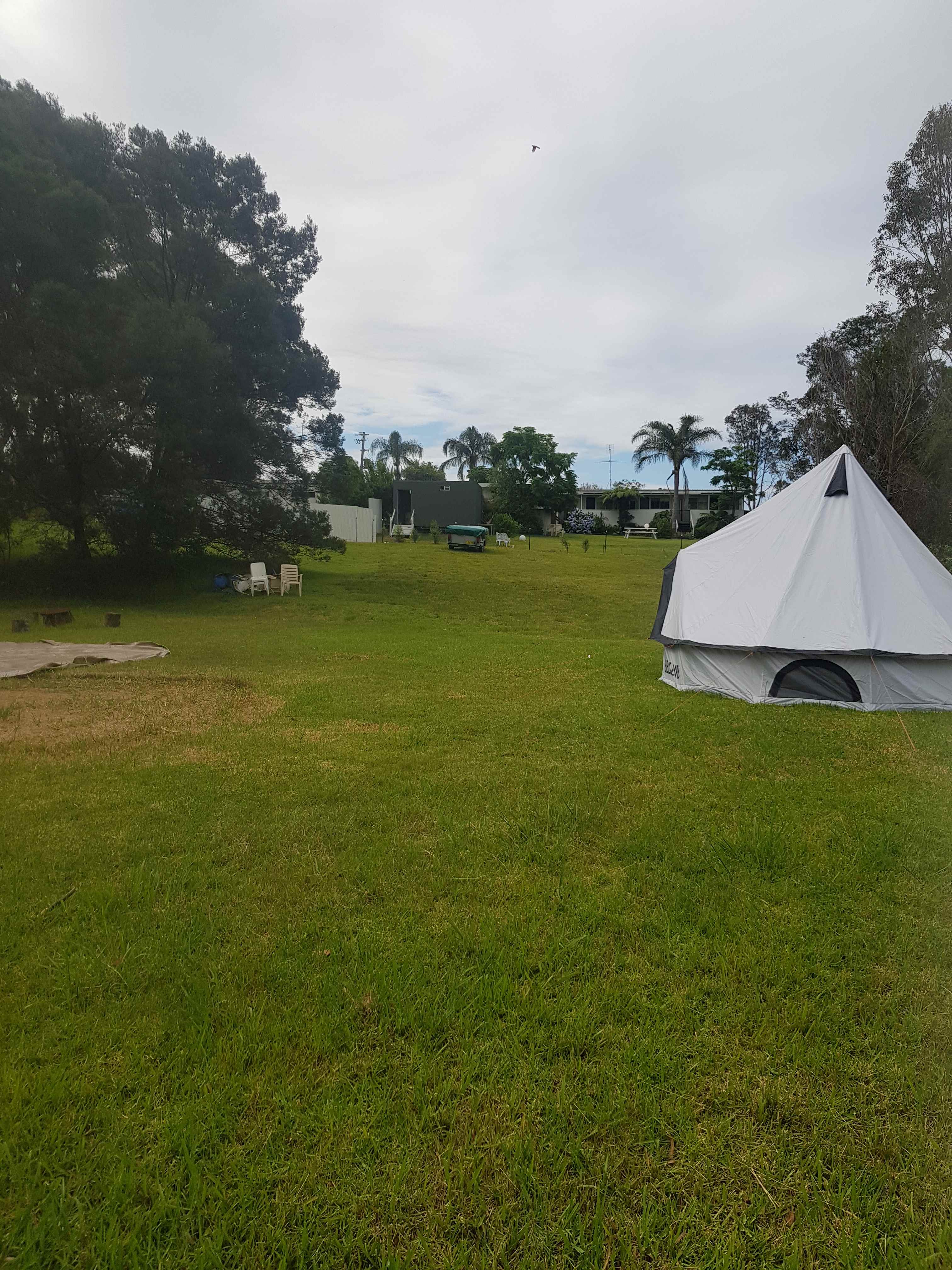 This is the large unpowered site.
Pictured is a 16ft bell tent and to the left you can see a grass mark from a 20 ft bell tent and there is still plenty of room.
The closest camper is up the hill where you can see a camp trailer. 
Behind the camp trailer is the amenities block