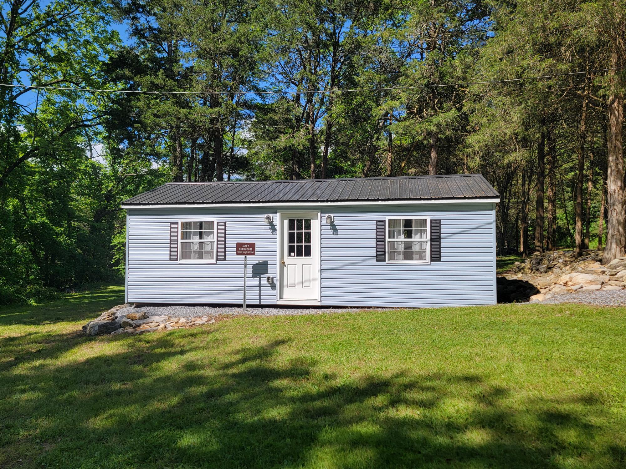Jake's Bunkhouse at Glamping Clear Spring Maryland 3-Cabin Campground, Jake's Bunkhouse has 4 queen beds, couch, heat and AC and a chair.